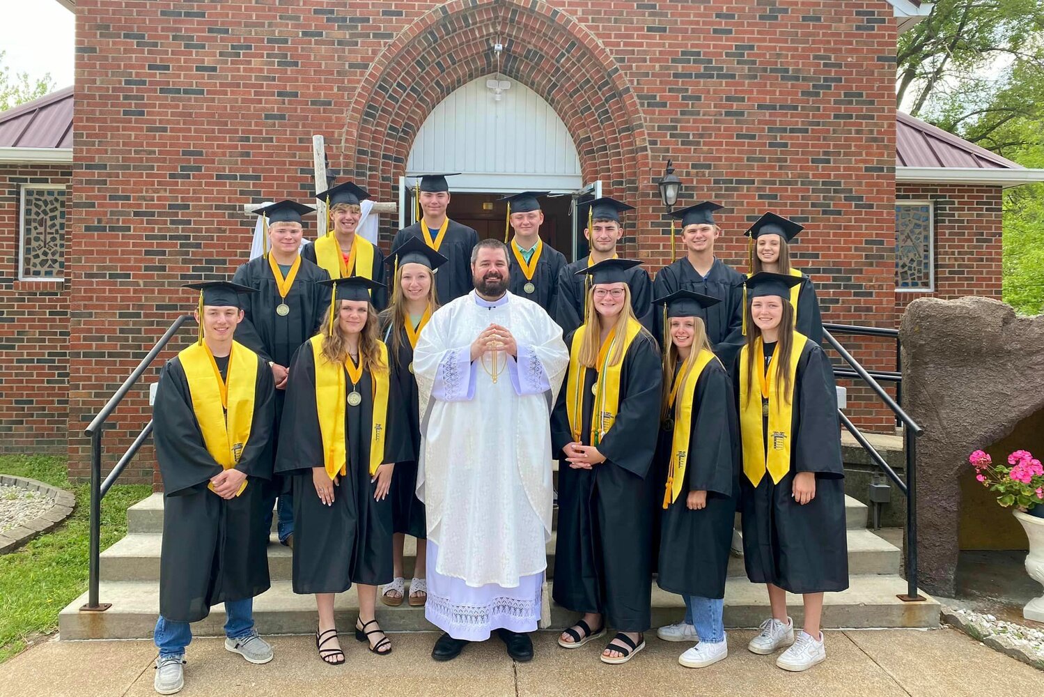 Father Christopher Aubuchon, parochial administrator of St. Lawrence Parish in St. Elizabeth and St. Anthony of Padua Parish in St. Anthony, gathers with parishioners in the Class of 2023 after Mass on May 14 in St. Anthony of Padua Church.